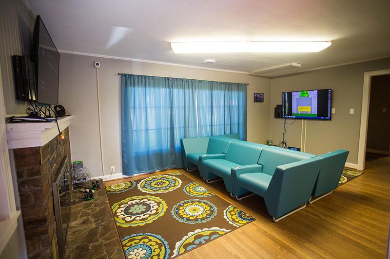 A room featuring sofas, televisions, cameras and gaming systems.