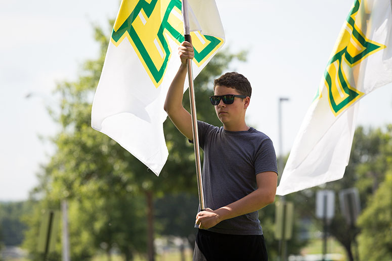 student holding flag for marching band