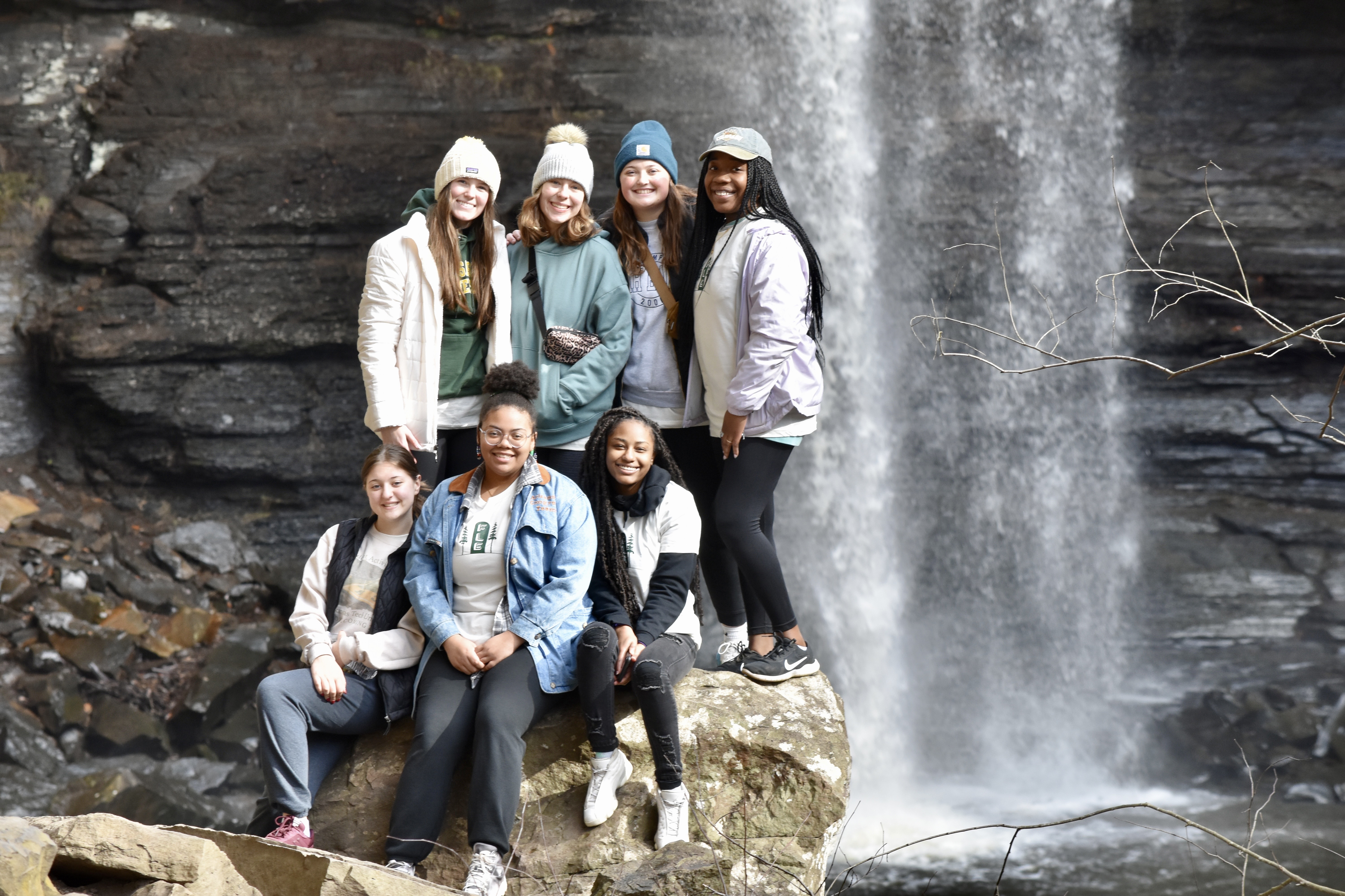 students standing by waterfall