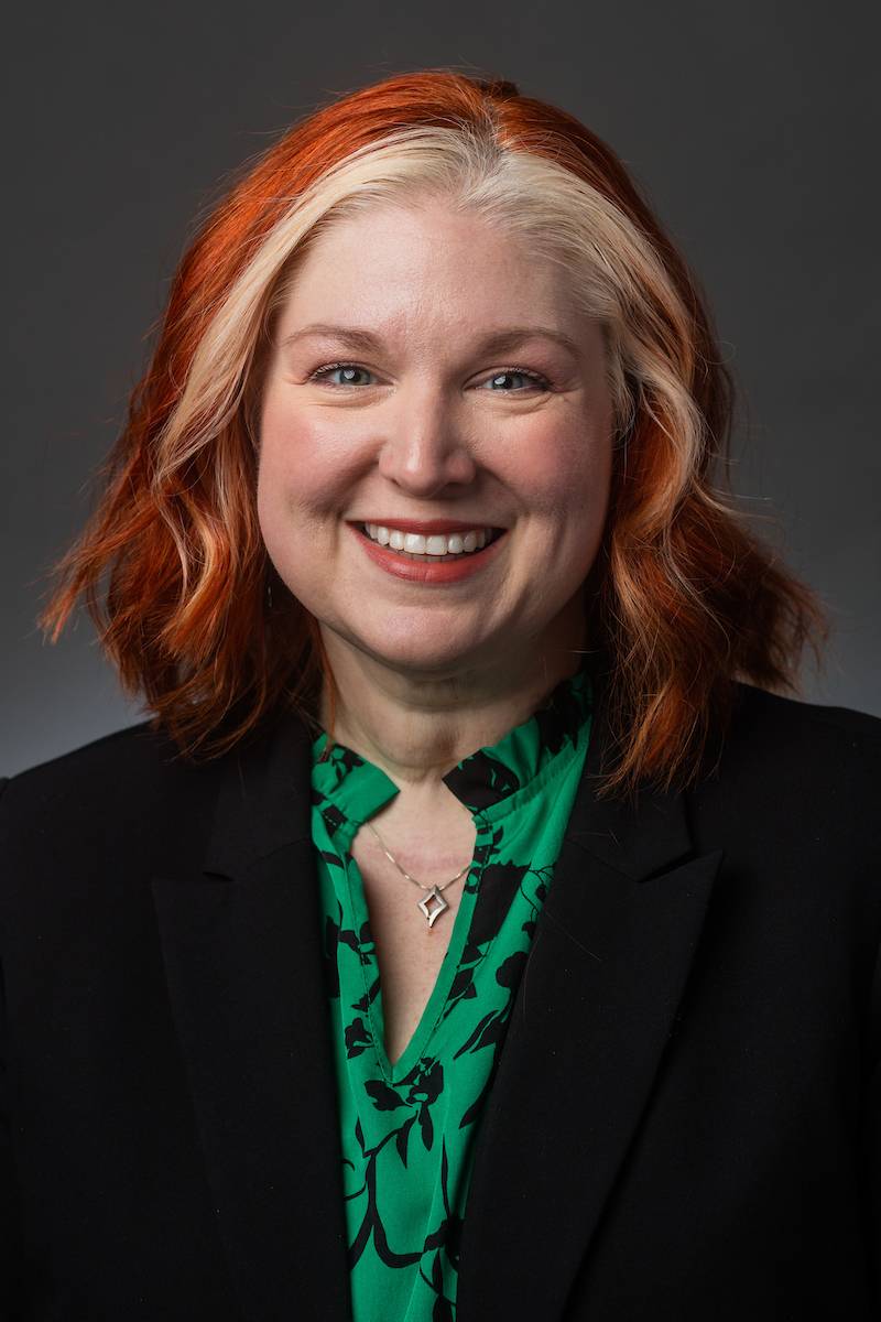 The head and torso of a smiling white woman