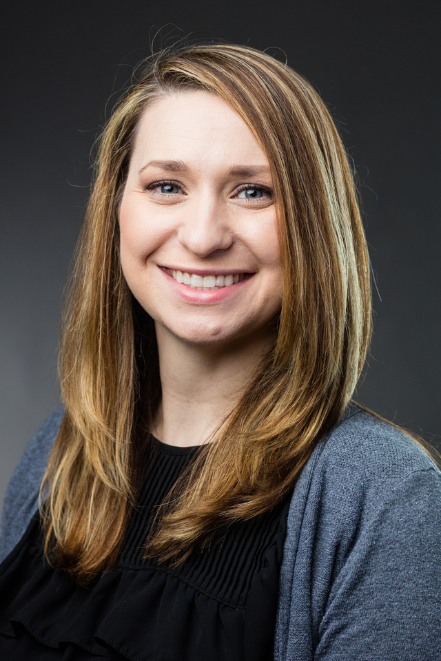 The head and shoulders of a smiling white woman with brown hair