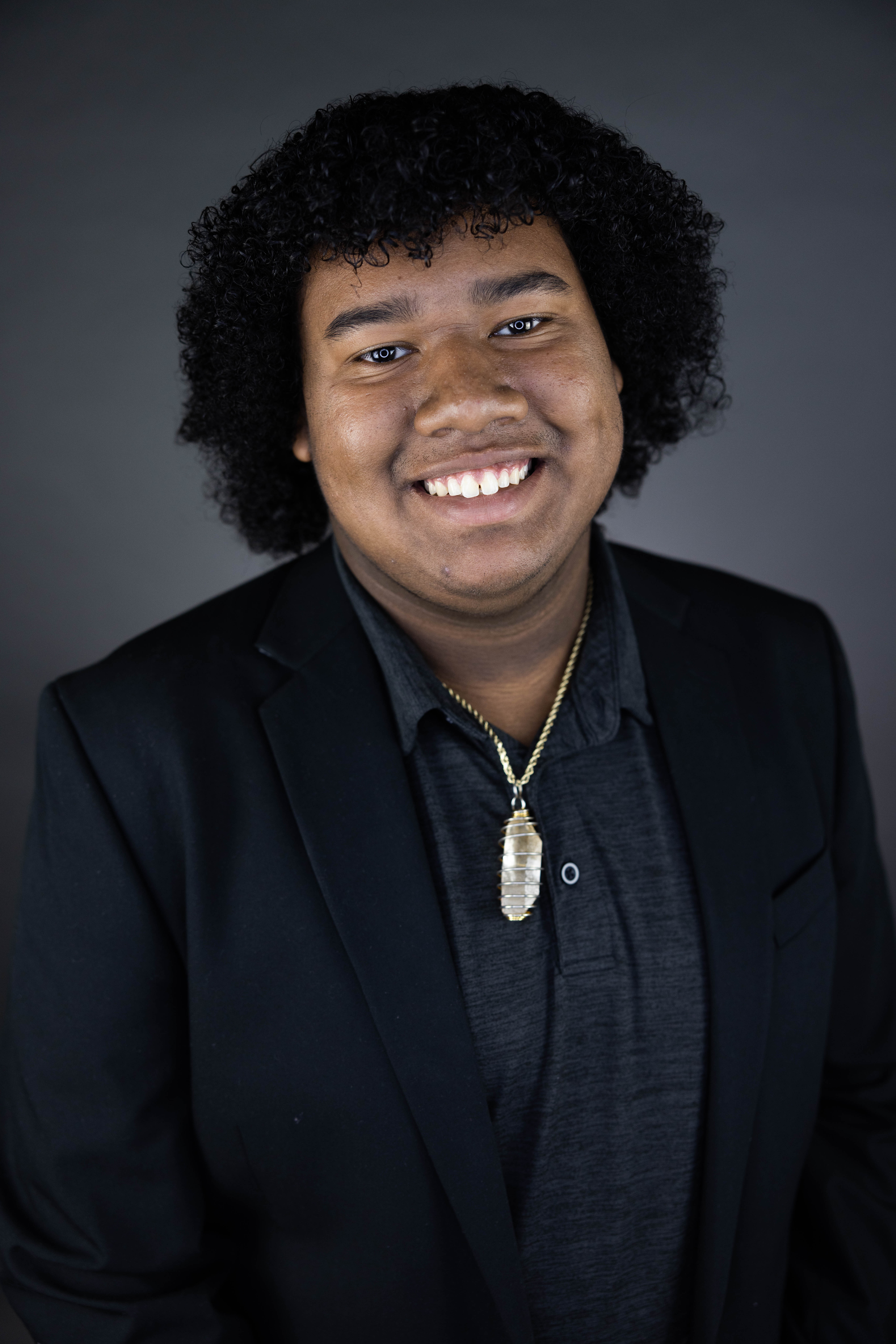 The head and torso of a smiling black man