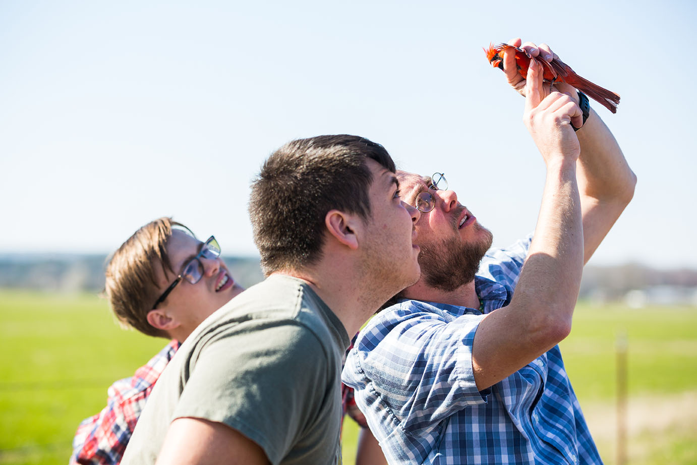 two students investigate a live bird at a biology event
