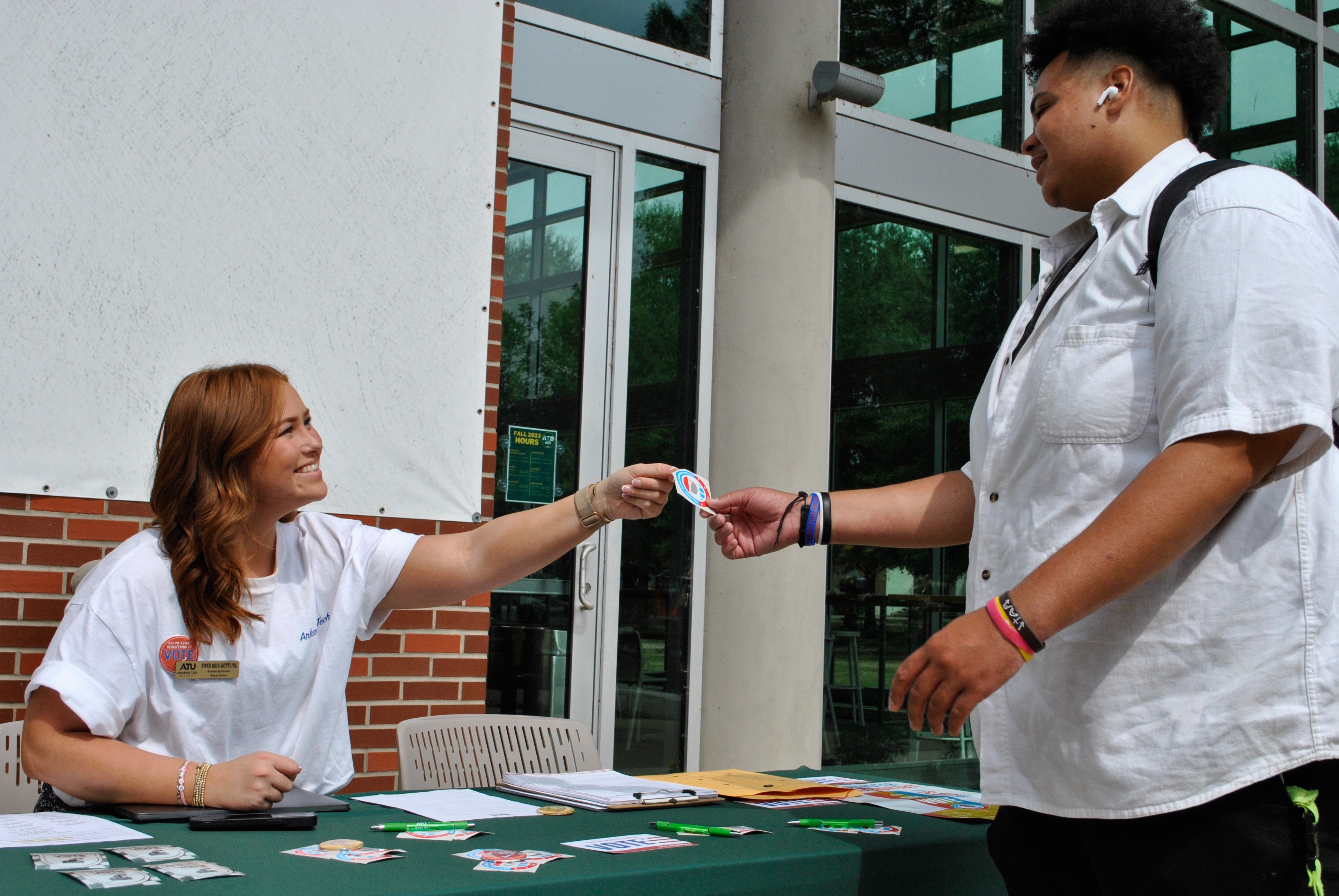 Graduate Assistant handing out items to students